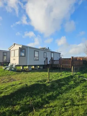 a tiny house on a trailer in a field at Static Caravan 10 in Lansallos