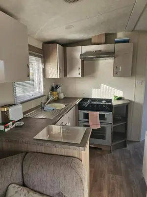 a small kitchen with a stove and a sink at Static Caravan 10 in Lansallos