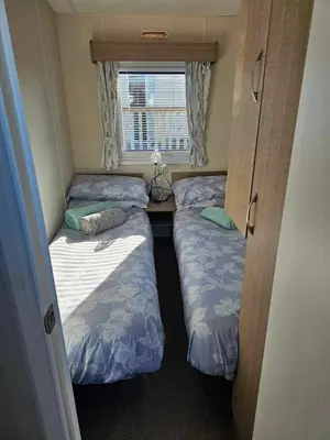 a small room with two beds and a window at Static Caravan 10 in Lansallos