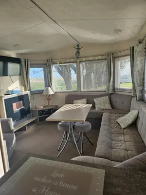 a living room with a couch and a table at Static Caravan 10 in Lansallos