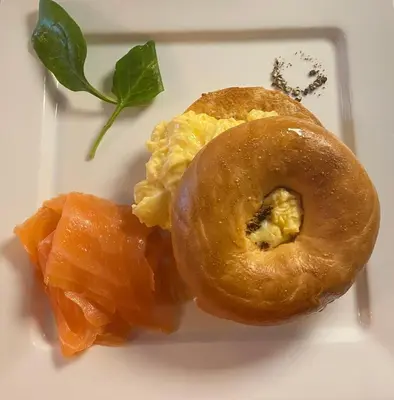 a white plate with a bagel and salmon on it at The White House Hotel in Newquay