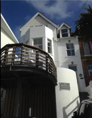 a white house with a wooden fence in front of it at The White House Hotel in Newquay