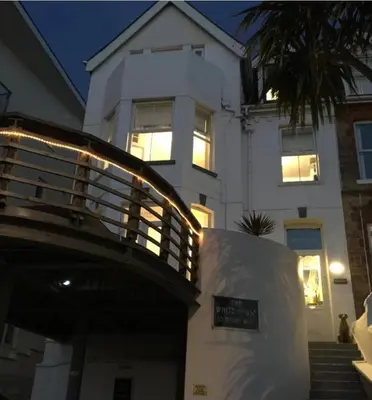 a large white building with a staircase in front of it at The White House Hotel in Newquay