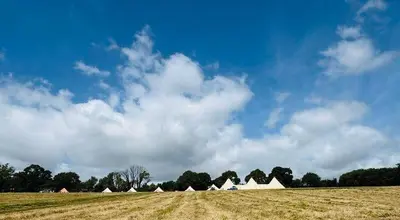 a field with white tents in the middle of a field at Barrel Cabin 2 in Trethurgy