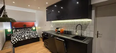 a kitchen with a sink and a bed in a room at Hove Too in Saint Day
