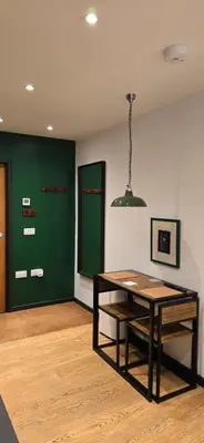 a room with a table and a green wall at Hove Too in Saint Day