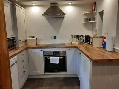 a kitchen with white cabinets and a wooden counter top at 2 Umfula Place in St Ives