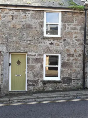 a brick building with a green door and two windows at 2 Umfula Place in St Ives