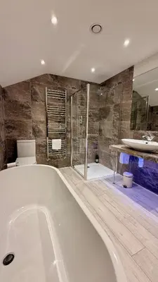 a large bathroom with a tub and a shower at The Vineyard in Fowey
