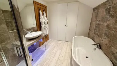 a bathroom with a white tub and a sink at The Vineyard in Fowey