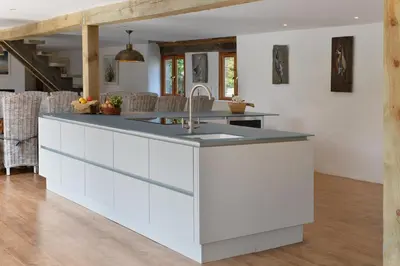 a kitchen with white cabinets and a sink at The Vineyard in Fowey