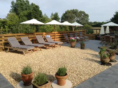 a group of chairs and umbrellas on a patio at The Vineyard in Fowey
