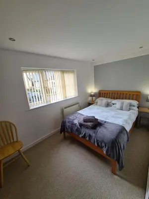 a bedroom with a bed and a chair and a window at Inny Glade in Davidstow