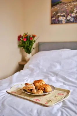a plate of pastries on a tray on a bed at Goonrea in Looe