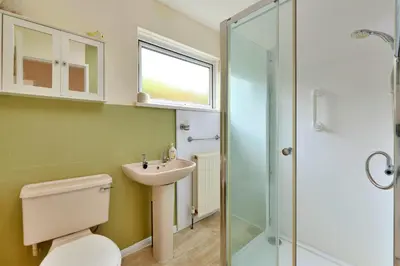 a bathroom with a toilet and a sink and a shower at Goonrea in Looe