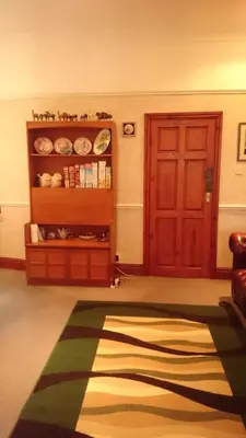 a living room with a red door and a rug at Bankside Bed & Breakfast in St Austell