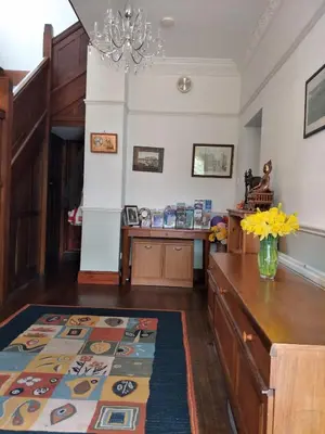 a living room with a table and a vase of flowers at Bankside Bed & Breakfast in St Austell