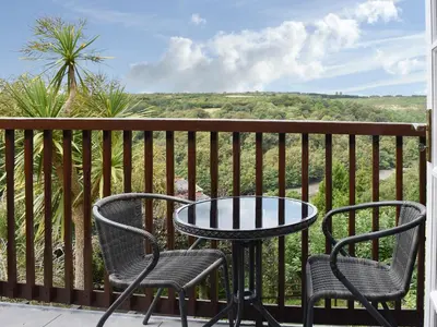 a table and chairs on a balcony with a view at Little Larnick in Looe