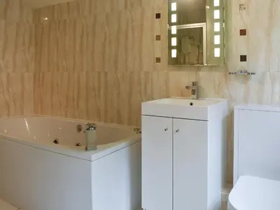 a bathroom with a sink and a bath tub at Little Larnick in Looe