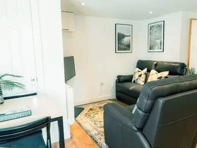 a living room with a couch and a table at The Pool House in Tywardreath