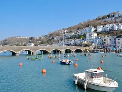 a group of boats in the water near a bridge at Watersmeet in Looe