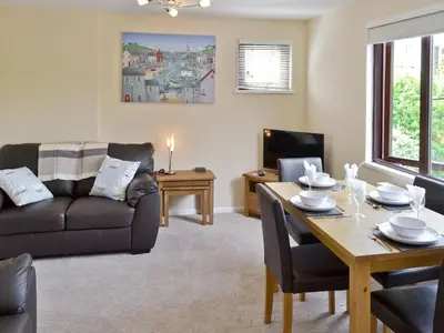 a living room with a table and a couch at Watersmeet in Looe