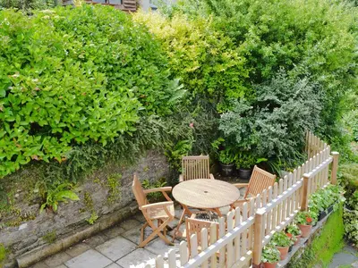 a wooden table and chairs in a garden at Watersmeet in Looe