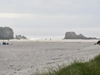 a beach with people and rocks in the ocean at Brambles in St. Agnes