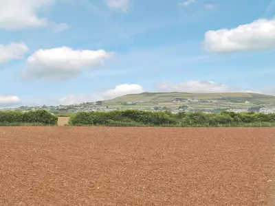 a dirt field with a mountain in the background at Brambles in St. Agnes