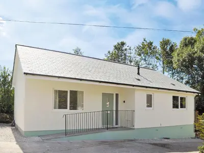 a white house with a black roof at Tegen in Tywardreath