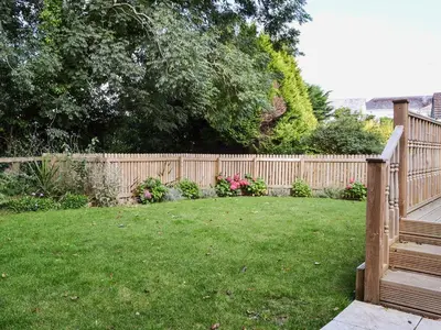 a backyard with a wooden fence and a yard at Tegen in Tywardreath