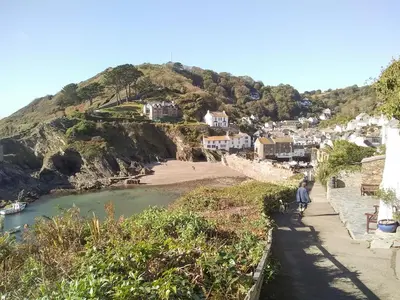 a person walking down a path next to a beach at Tucked Away in Linkinhorne