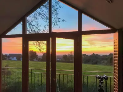 a view from a window of a sunset at The Roost in Saint Breward