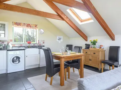 a kitchen and dining room with a table and chairs at The Roost in Saint Breward
