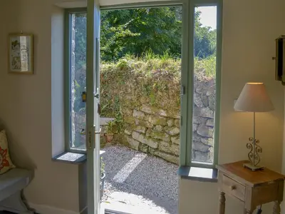 an open door with a view of a stone wall at The Roost in Saint Breward