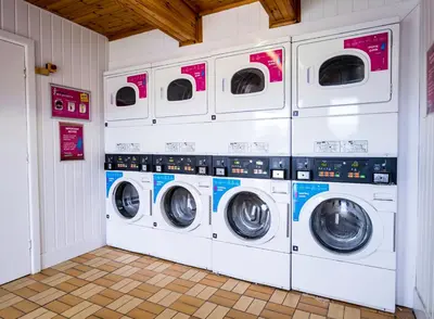 a row of washing machines in a laundry room at Newquay Bay Holiday Resort in Newquay