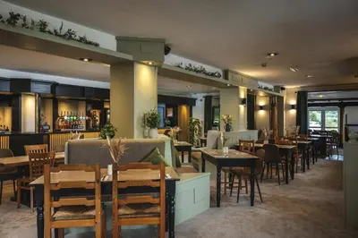 a dining room with tables and chairs in a restaurant at The Inn For All Seasons in Redruth