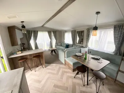 a living room with a couch and a table at Widemouth Bay Caravan Park in Bude