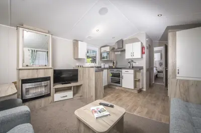 a large living room with a couch and a table at Widemouth Bay Caravan Park in Bude