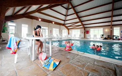 a woman standing at a table in a swimming pool at Widemouth Bay Caravan Park in Bude