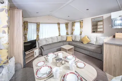 a living room with a couch and a table at Trelawne Manor Holiday Park in Looe
