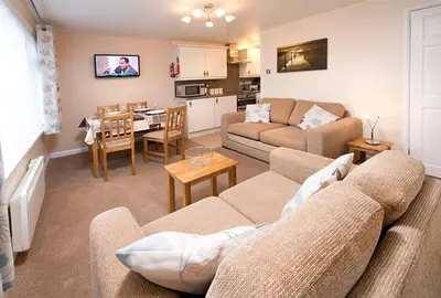 a living room with a couch and a dining room at Trelawne Manor Holiday Park in Looe