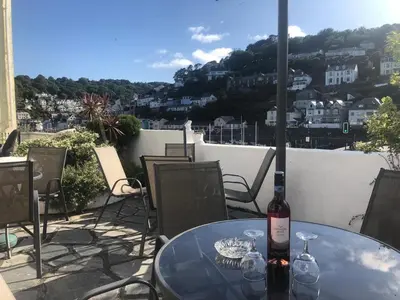 a bottle of wine sitting on a table on a patio at Bridgeside Guest House in Looe