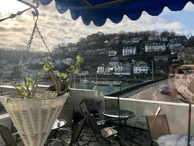 a balcony with a table and chairs and a view of a city at Bridgeside Guest House in Looe