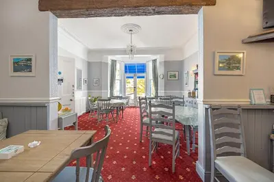 a room with tables and chairs and a dining room at Bridgeside Guest House in Looe