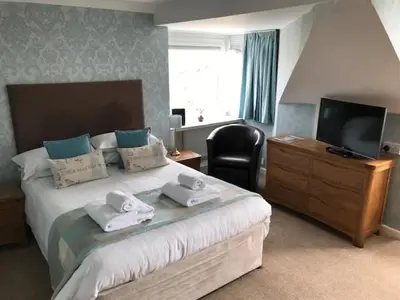 a hotel room with a bed with towels on it at Cotswold House in Falmouth