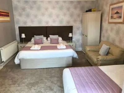 a bedroom with a large bed and a couch at Cotswold House in Falmouth