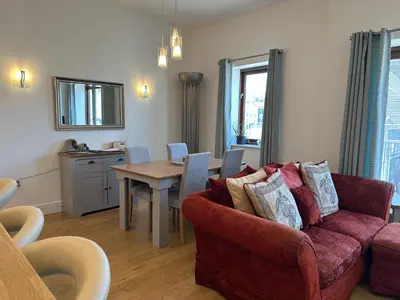 a living room with a couch and a table at Tidemill House Apartment in Falmouth