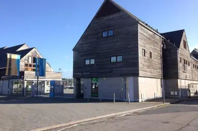 a large wooden building on the side of a street at Tidemill House Apartment in Falmouth