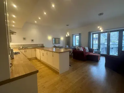 a large kitchen and living room with a couch at Tidemill House Apartment in Falmouth